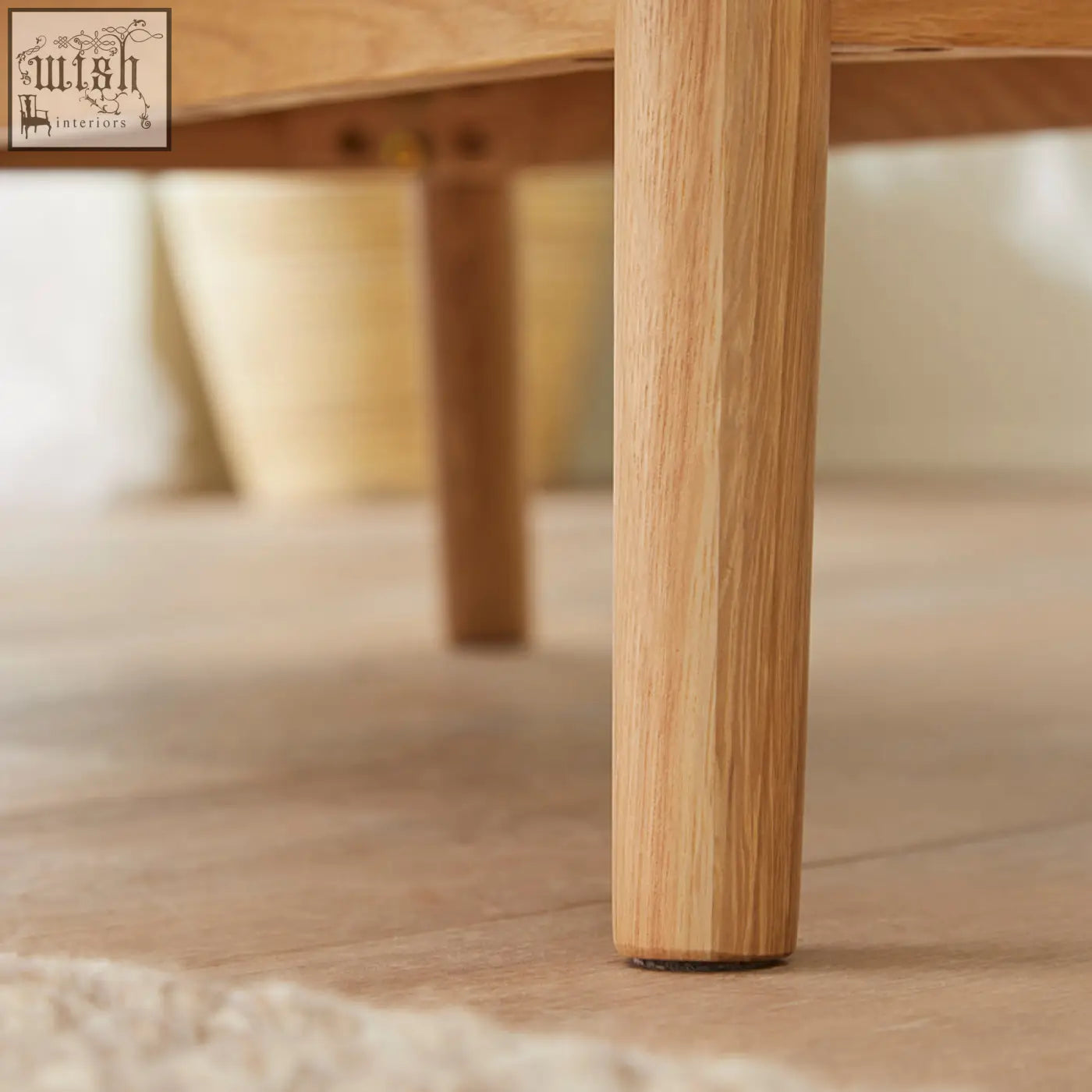 Light oak wooden leg with smooth natural grain and rounded base of wright oak chest of 3 drawers oak chest