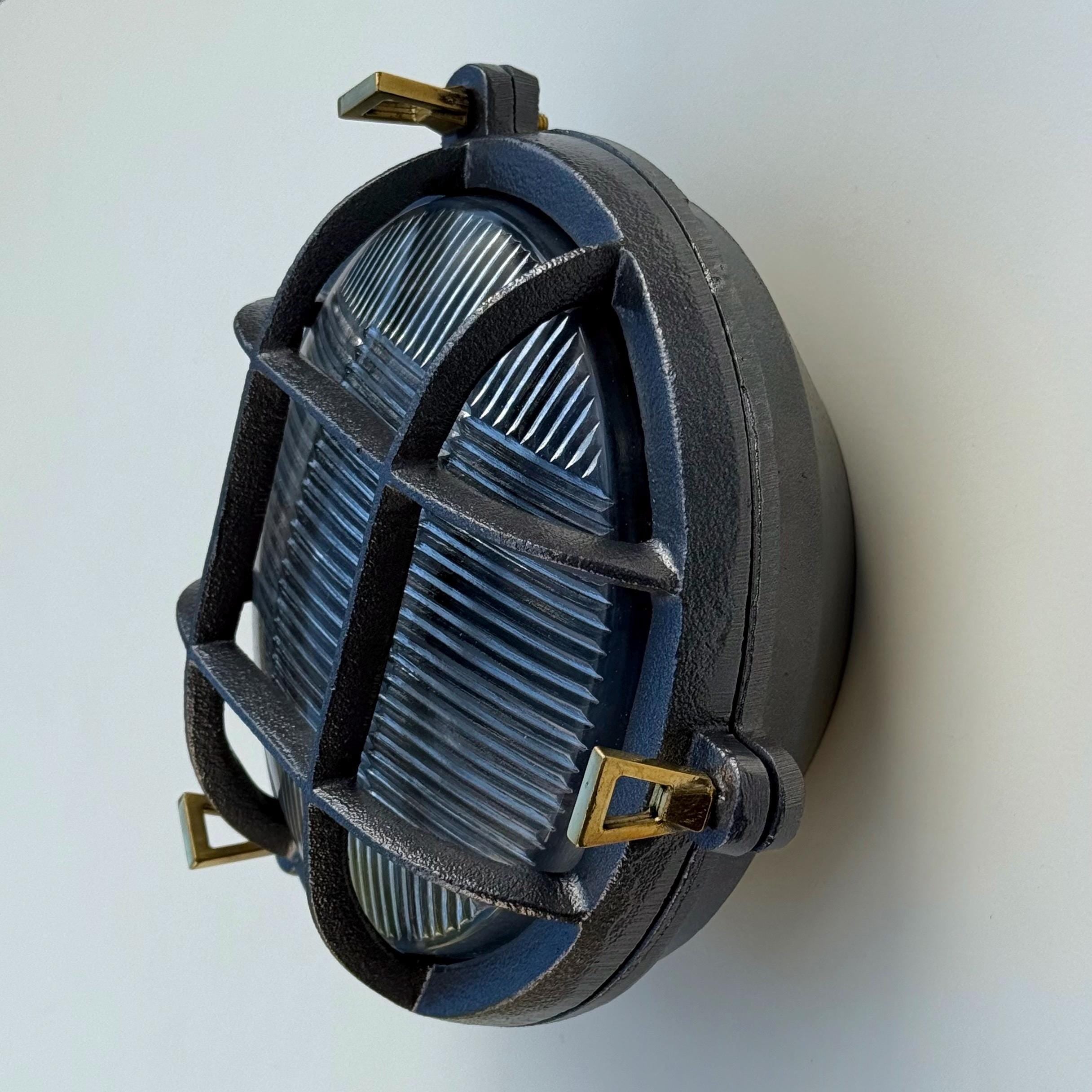 Dark gray cast iron wall light with brass hardware and ribbed glass lens nautical bulkhead wall light design