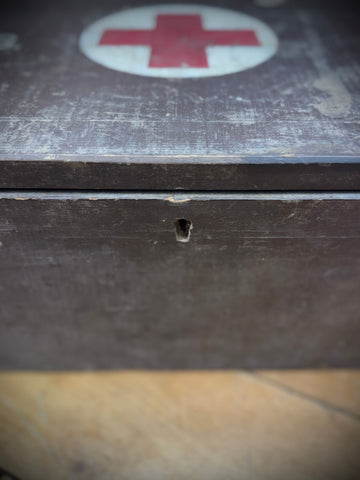 Worn dark wooden wwii civil defence aid box with faded red cross emblem vintage first aid medical case