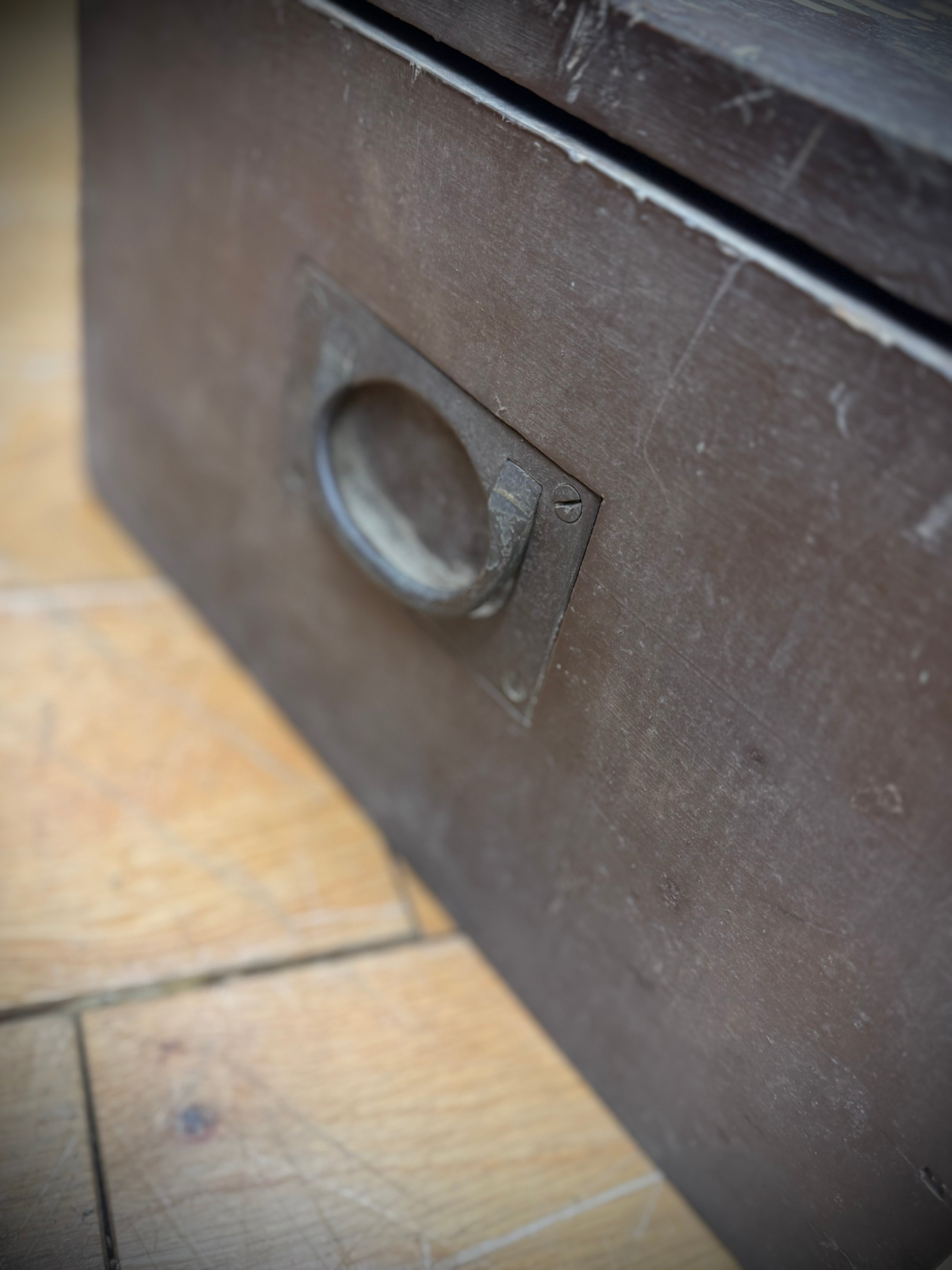 Dark brown wooden drawer with circular metal pull handle on wwii civil defence red cross aid box vintage medical case