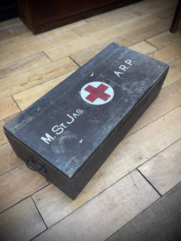 Dark gray wooden civil defence aid box with red cross emblem and white lettering vintage wartime medical case