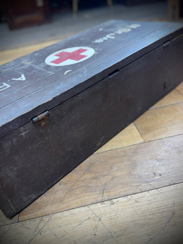 Dark wooden WWII aid box with red cross emblem used for civil defence medical supplies and vintage storage