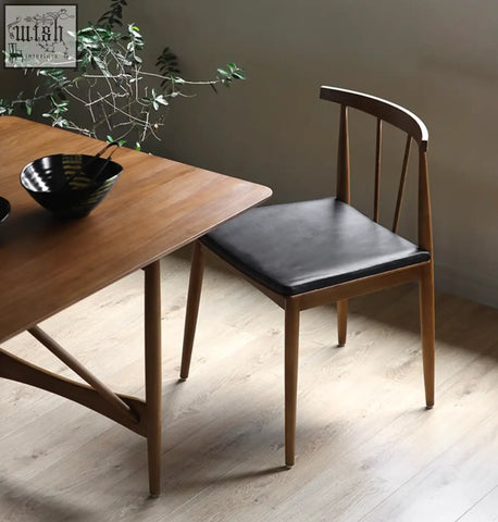 Mid-century modern wyatt dining chair with black leather seat and wooden curved backrest for dining room use