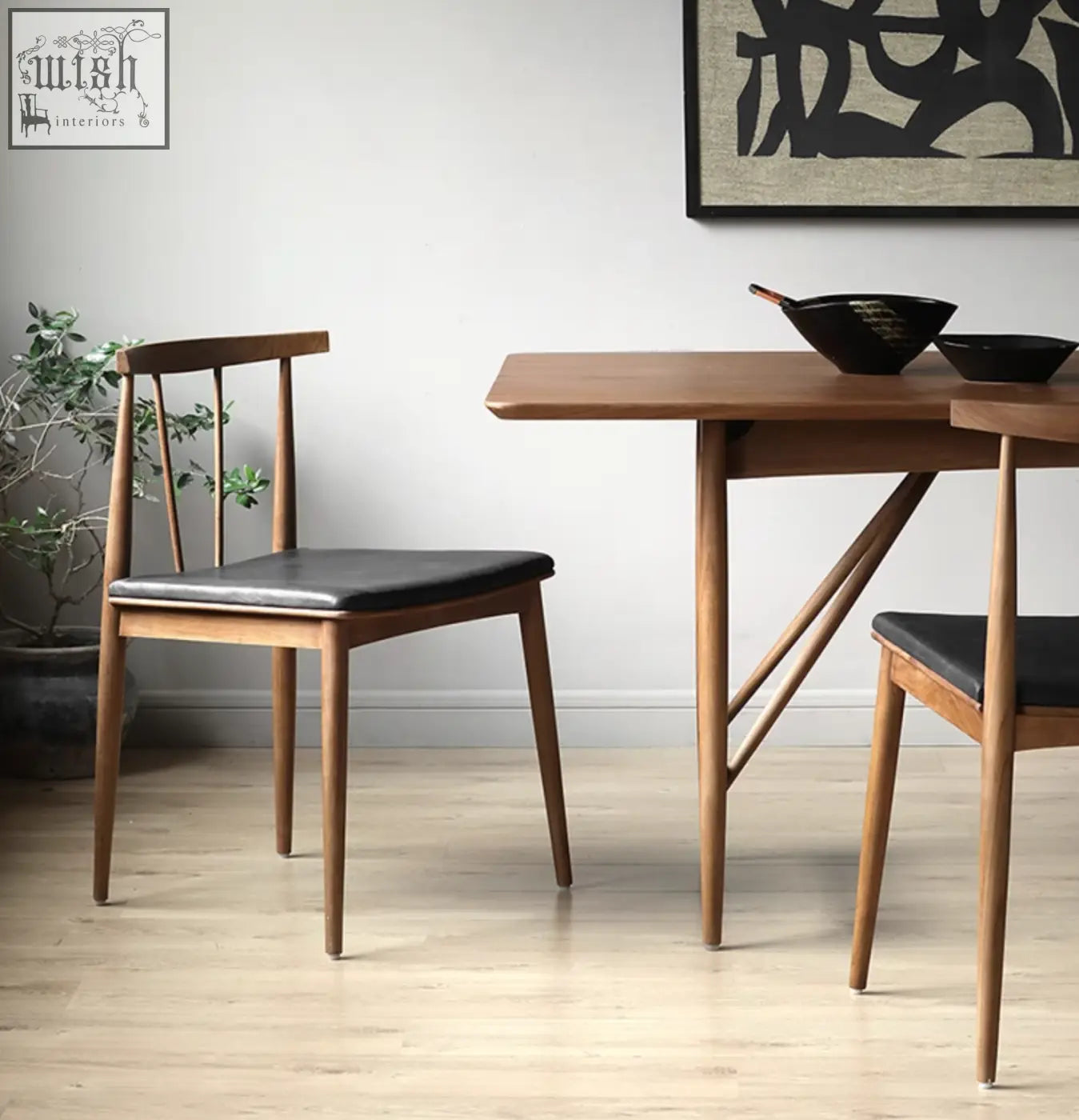 Wyatt dining chair with black leather seat and backrest and wooden frame in mid-century modern style