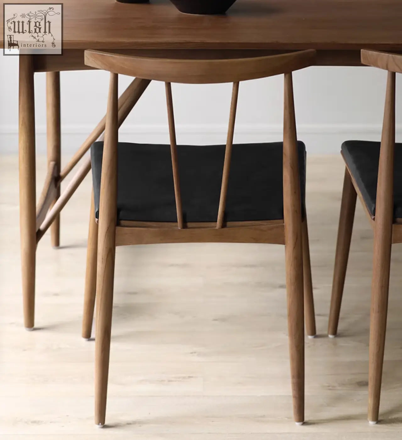 Modern wooden wyatt dining chair with black upholstered seat and slender tapered legs for stylish dining rooms