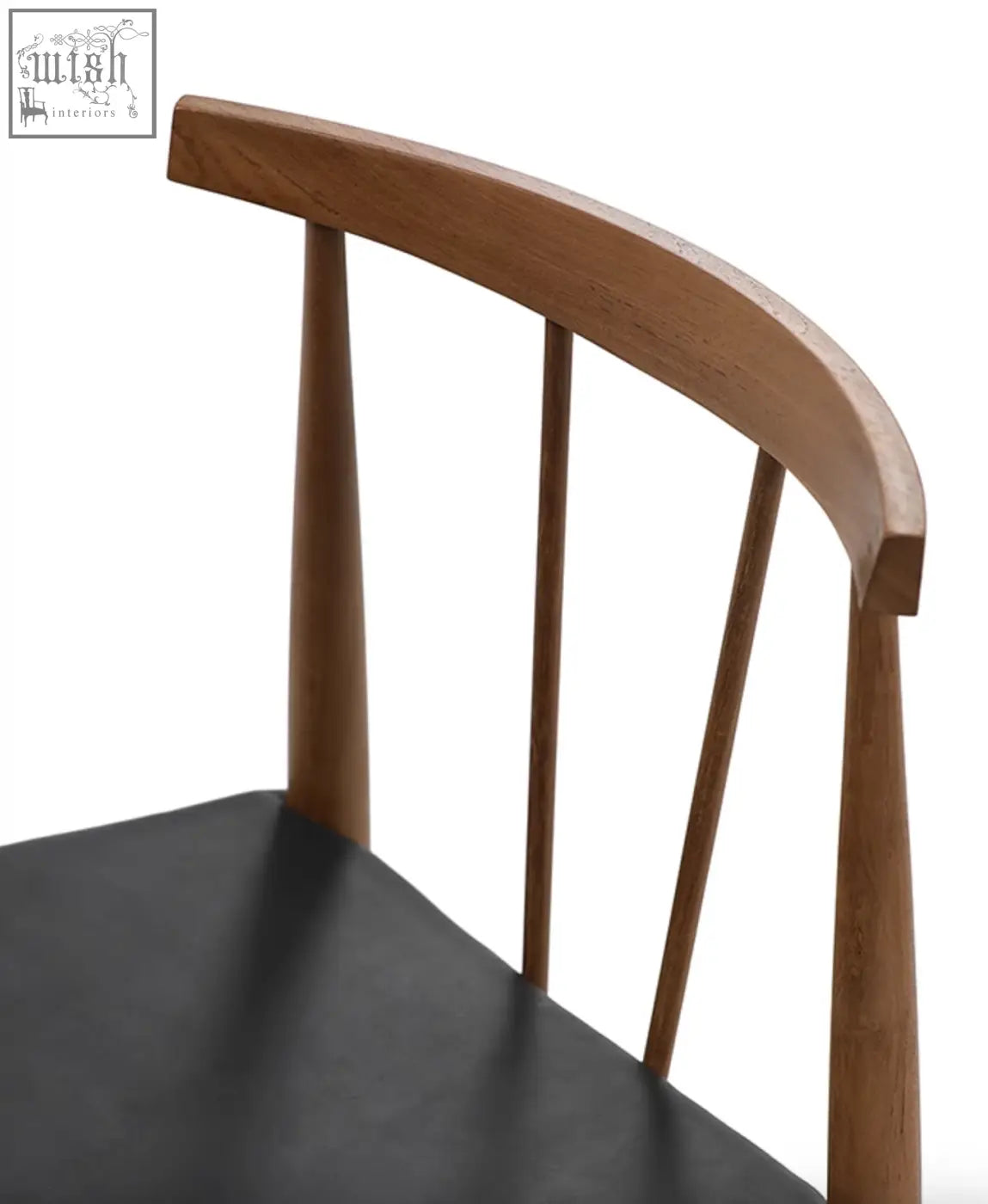 Back of wyatt dining chair showing curved wooden brown spindles and black upholstered seat in a dining chair design