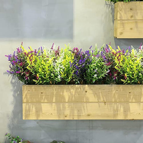 A vibrant multicolored faux flowers arrangement in a light wooden planter box ideal for outdoor fake plants decor