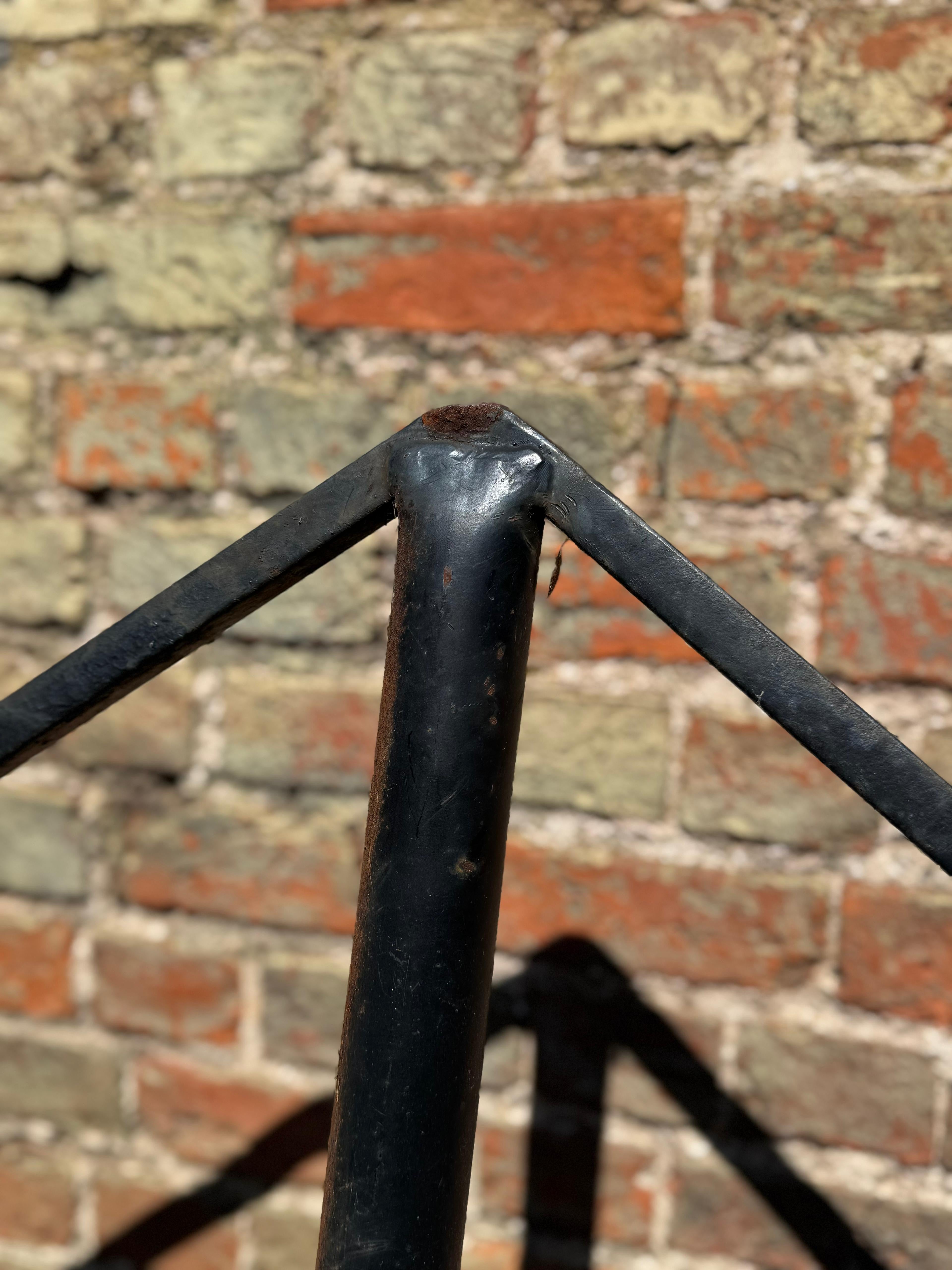 Black metal star garden stake post with welded joint against brick wall for christmas wedding decor
