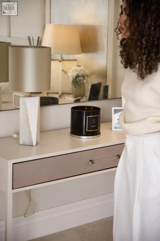 Black cylindrical xl candle with gold trim and label featuring white musk scent and sleek modern design