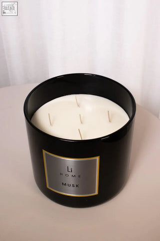 Black cylindrical candle jar with creamy white wax and four wicks scented with white musk in xl candle musk