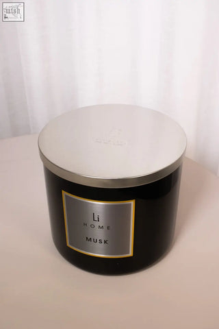 Black cylindrical xl candle with silver lid and gold trimmed label li home musk featuring white musk scent