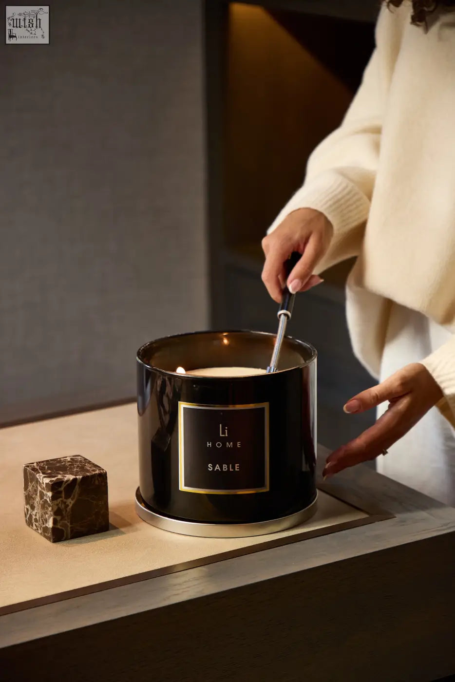 A black xl candle with a gold li home sable label and silver base perfect for elegant home decor