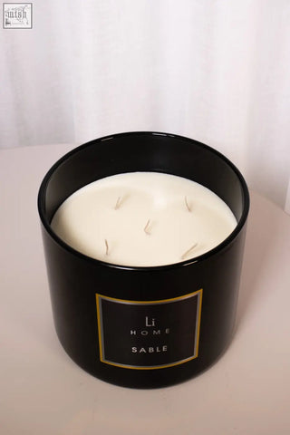 Black cylindrical xl candle jar with glossy finish four wicks creamy white wax and gold trimmed li home sable label