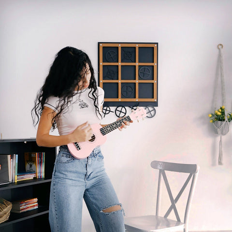 Pink ukulele with glossy finish and black fretboard for xox board three in a row tic tac toe game fun