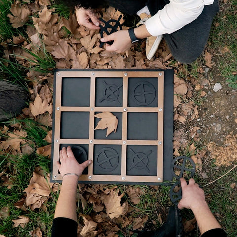 Black and tan wooden tic tac toe board with metal screws and engraved symbols for three in a row fun