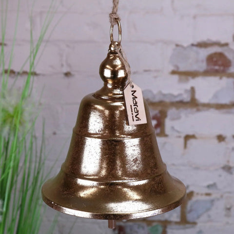A rustic gold-finished metal yanika hanging bell with textured surface and rope loop featuring a marav tag