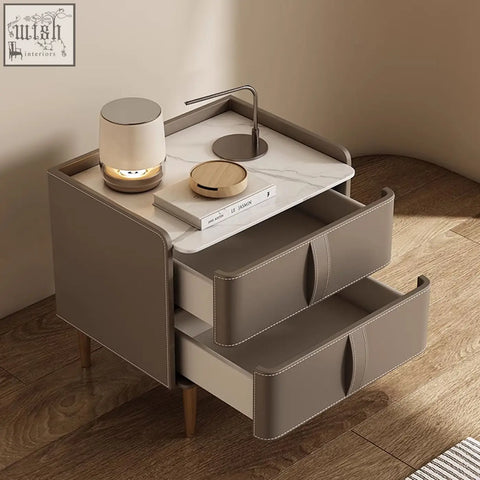 Modern gray leather yano bedside table with marble top, two drawers, and slender solid wood legs in brown finish