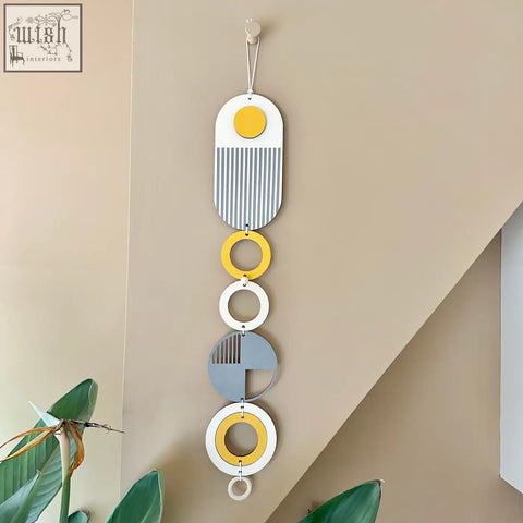 A modern geometric wall hanging featuring stacked white ochre yellow and grey circles with striped patterns wall art