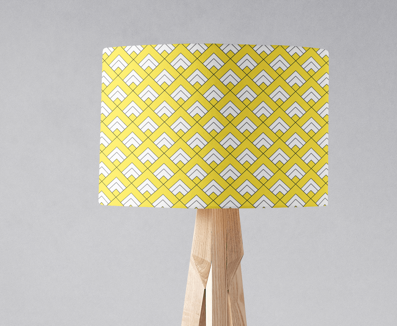Yellow and white geometric design lampshade with chevron pattern on light wood tripod base for table lamp use