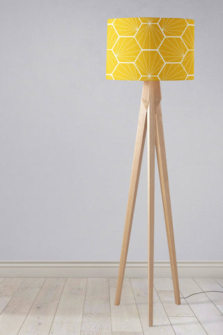 A modern table lamp with a yellow lamp shade featuring white hexagon design and light wood tripod legs, inch diameter shade
