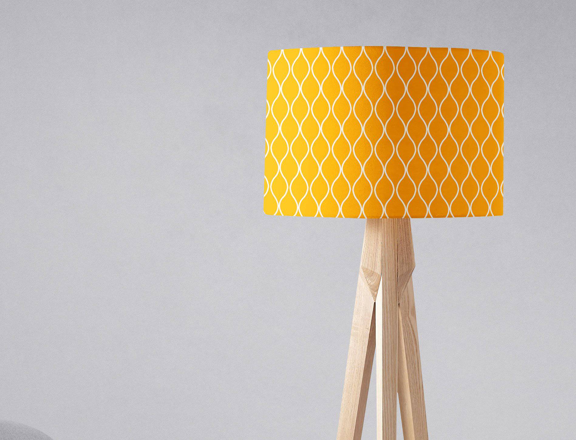 Yellow lampshade with white geometric design on a light wood tripod base perfect as a table lamp shade