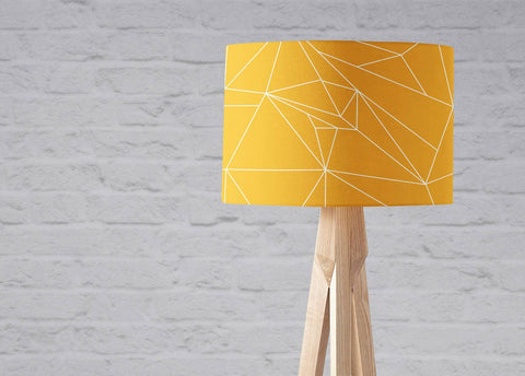 Yellow lampshade with white lines geometric design on a light wood tripod base table lamp shade