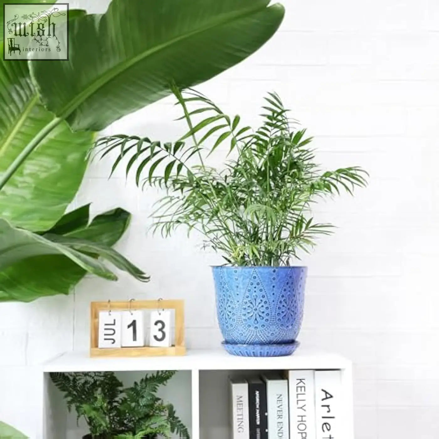 Blue beaded ceramic planter with intricate lace pattern and drain holes holding a lush green fern for indoor outdoor use