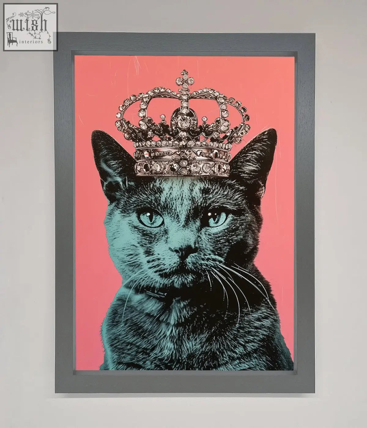 A framed print of a majesty cat framed featuring a black cat with teal eyes and a jeweled silver crown on pink background