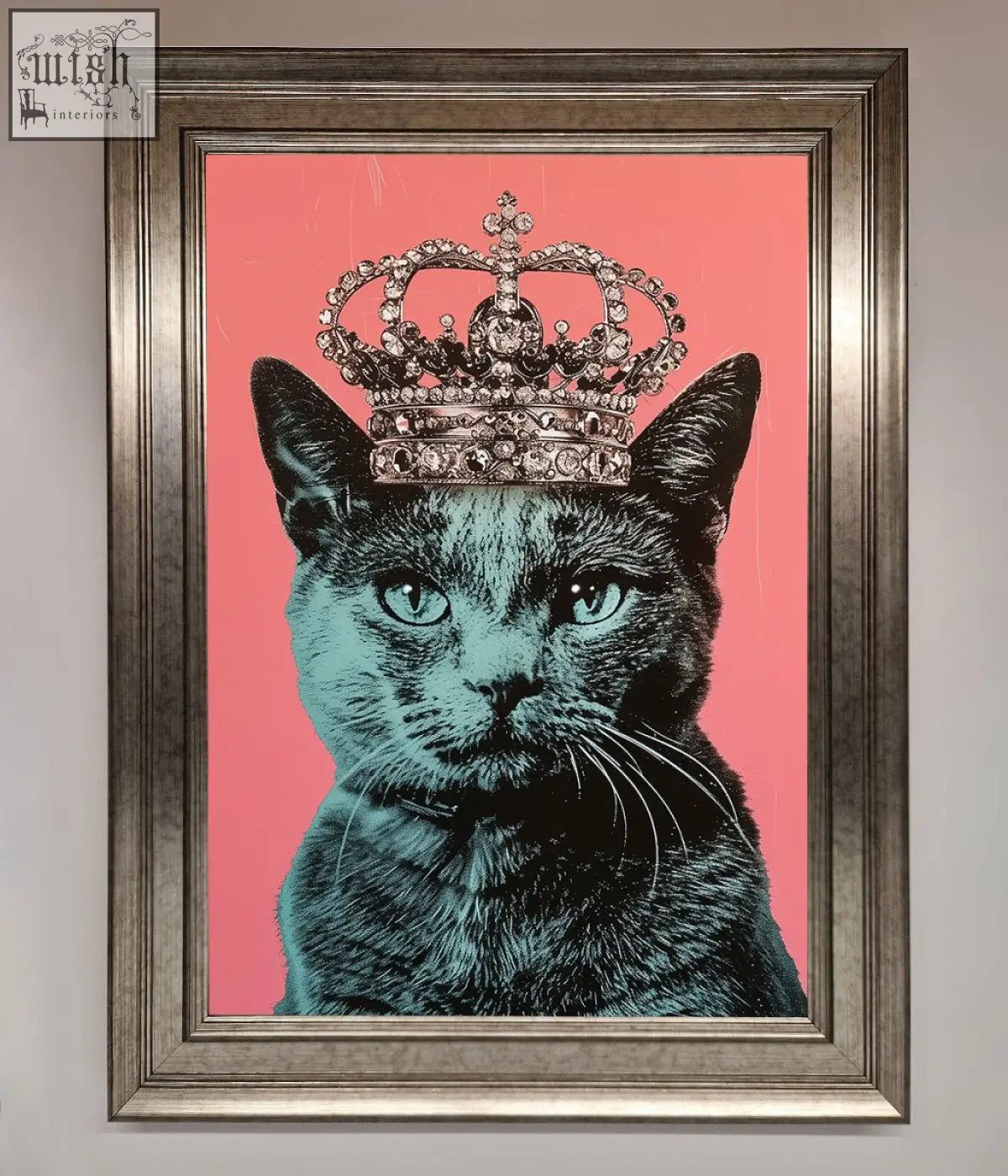 A framed print of a majesty cat framed featuring a black cat with teal eyes wearing a jeweled silver crown on pink background