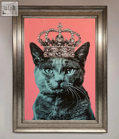 A framed print of a majesty cat framed featuring a black cat with teal eyes wearing a jeweled silver crown on pink background