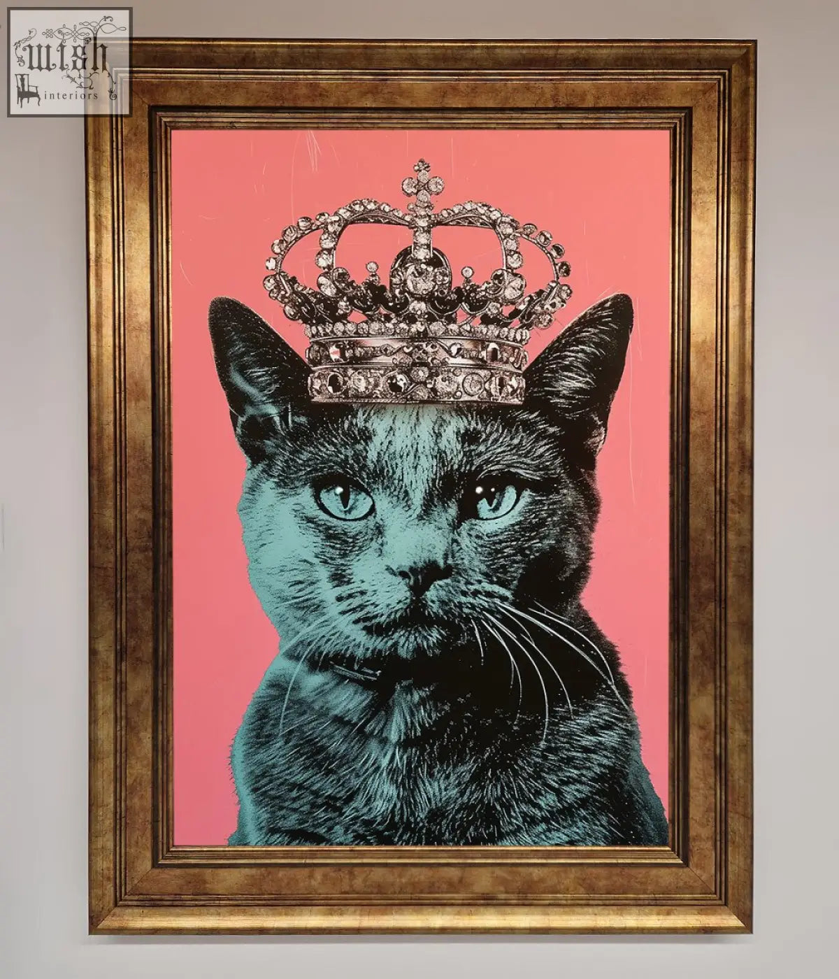 A framed print of a majesty cat framed featuring a black cat with teal eyes wearing a jeweled crown on pink background