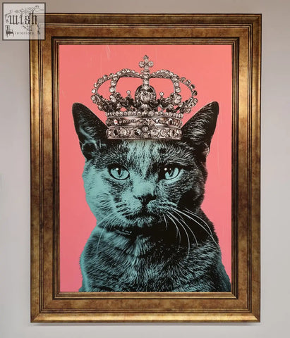 A framed print of a majesty cat framed featuring a black cat with teal eyes wearing a jeweled crown on pink background