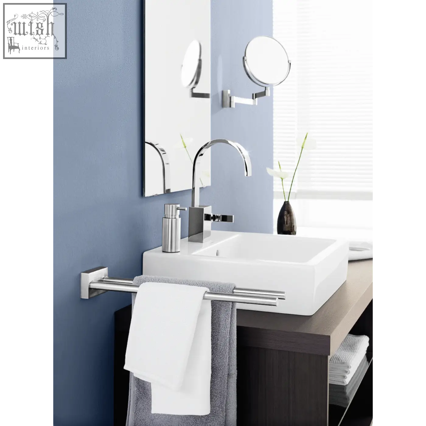 Chrome-finished double-bar towel rack on blue wall holding towels next to zack linea premium stainless steel cosmetic mirror
