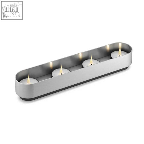 Modern brushed stainless steel lonta tealight holder with four lit tea light candles for stylish decor