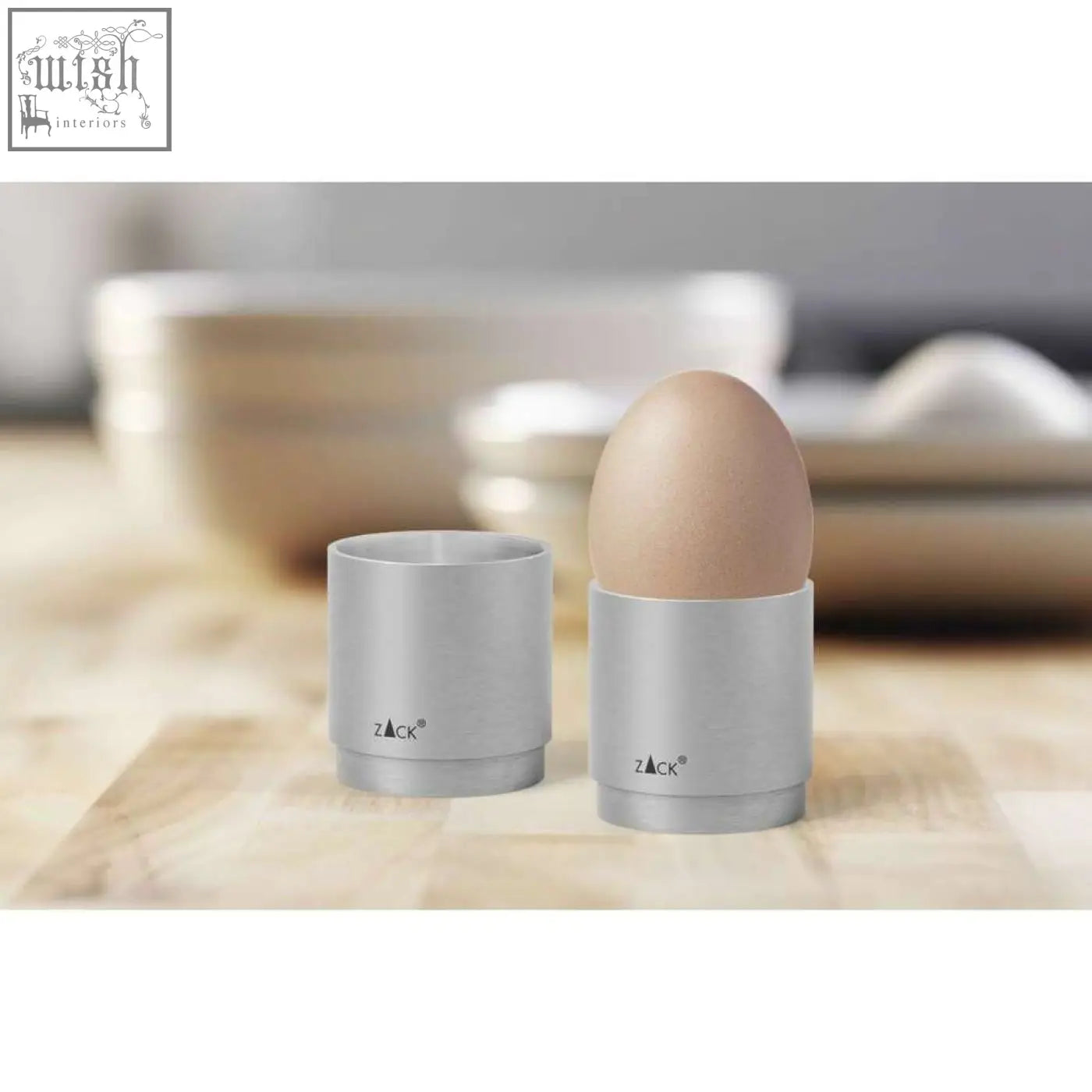 Silver zack stainless steel egg cup holding a brown egg from zack salo premium brushed egg cup set