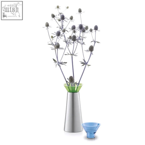 Silver metallic zack taris brushed stainless steel vase candle holder with green glass rim holding dried thistle stems and blue funnel