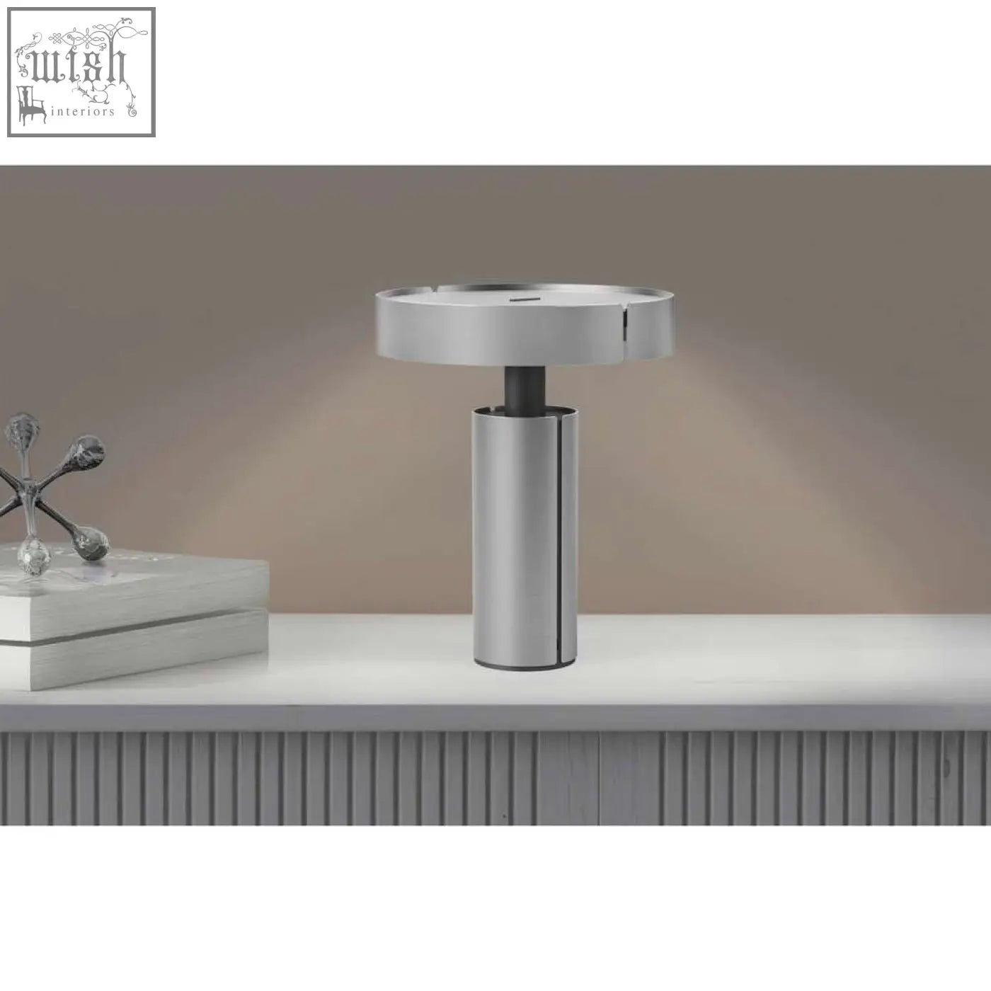 Modern silver metallic led table lamp with sleek cylindrical stainless steel base and circular top by zack yaro