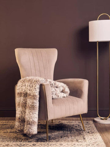 Beige zamora mink velvet accent chair with gold finish legs and a faux fur throw for cozy seating