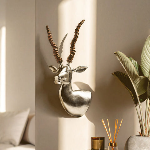 Silver gazelle wall-mounted sculpture featuring a metallic antelope head with intricately spiraled horns for decor