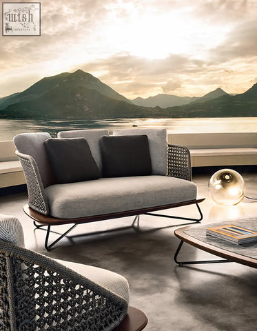 Modern gray woven zarina outdoor sofa with dark accent pillows and sleek metal frame in an outdoor sofa set