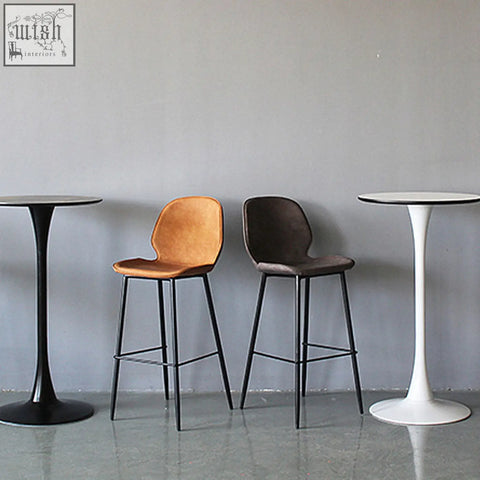 Two zavier bar stools with painted steel frames and velvet seats in warm tan and dark brown colors