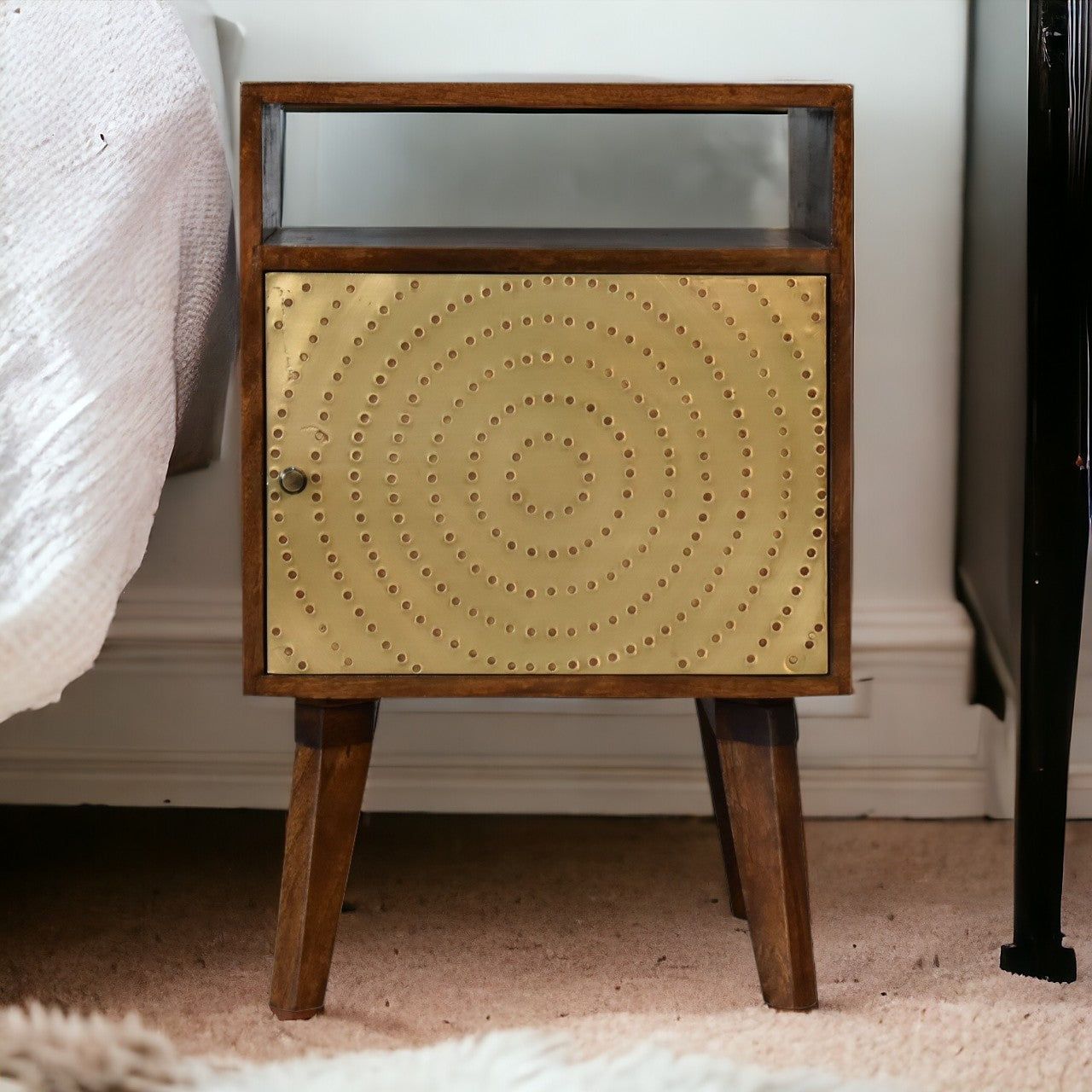 A mid-century modern zen bedside table in chestnut solid mango wood with a brass circular perforated panel