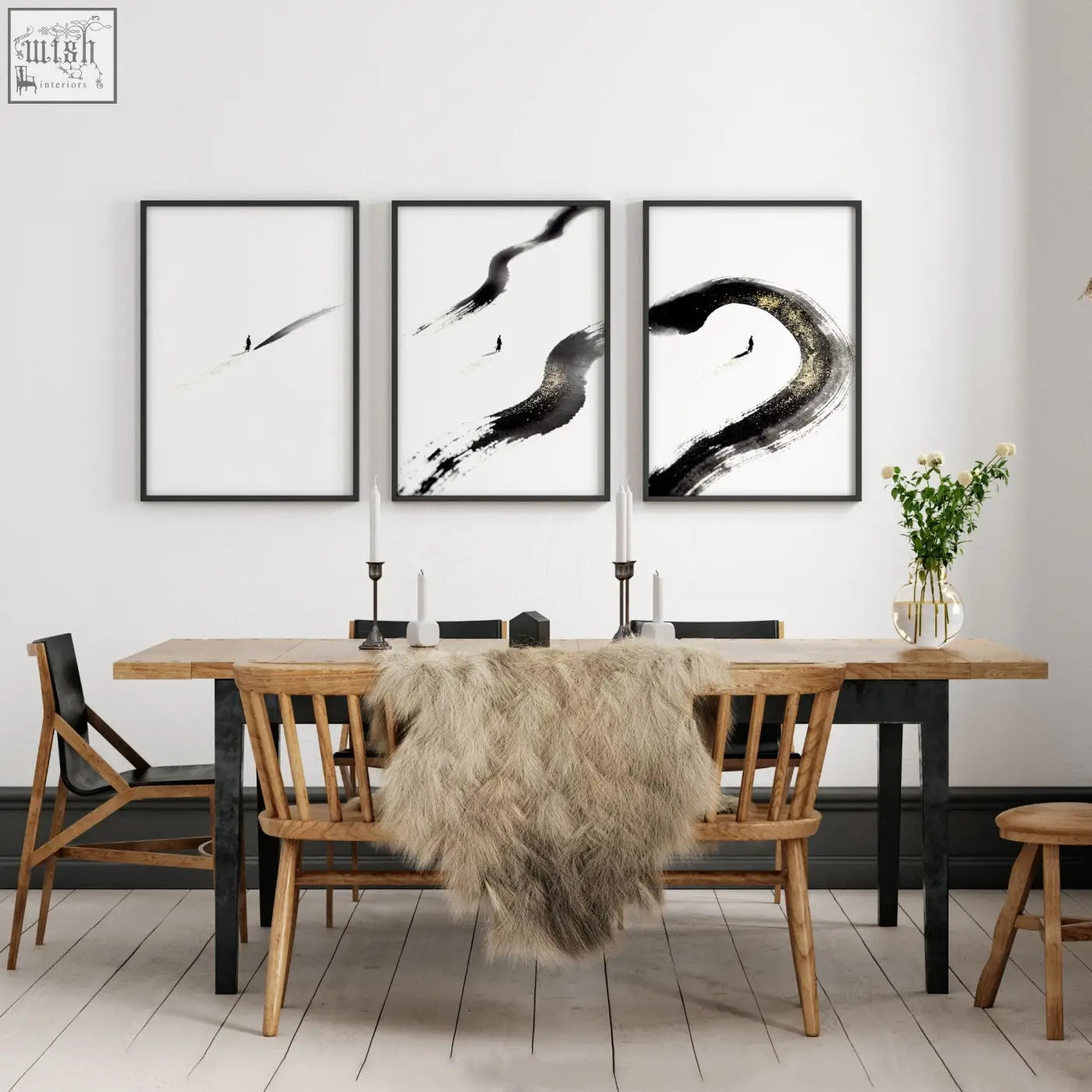 Three black and white ink brushstroke art prints with lone figure hang as zen wall decor above wooden dining room table