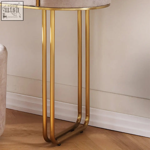 A zoey dressing table with an oval beige velvet top and gold metal legs perfect for stylish vanity setups