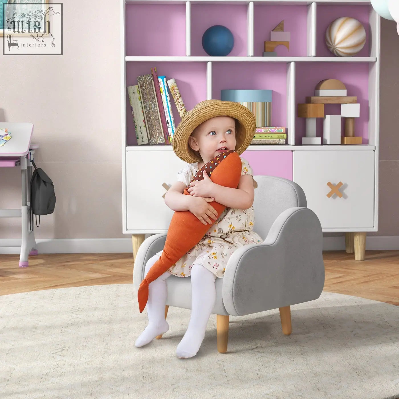 A child sits in a grey zonekiz kids armchair with plush fabric dutch velvet and supportive sponge holding a carrot toy