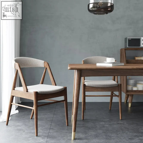 Modern zonka chair with warm wood angled legs and light gray upholstered seat and backrest