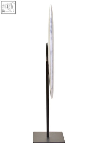 A zoro extra large round mirror with a thin metallic frame and dark bronze stand paired with a white marble disc sculpture