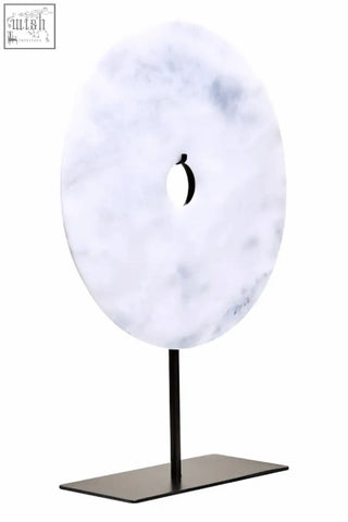 Zoro large round white marble disc sculpture with central hole displayed on sleek black metal stand