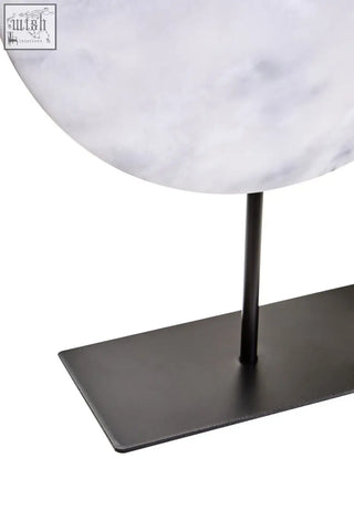 A zoro large round 30cm white marble disc sculpture on a sleek matte black metal stand