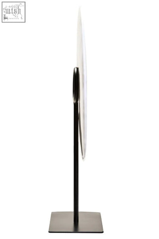 A sleek zoro large round mirror with a black metal stand complements the white marble disc sculpture design
